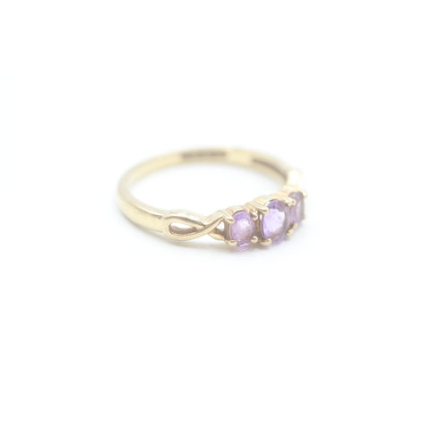 165 - 9ct gold amethyst three stone ring (1.9g) Size P