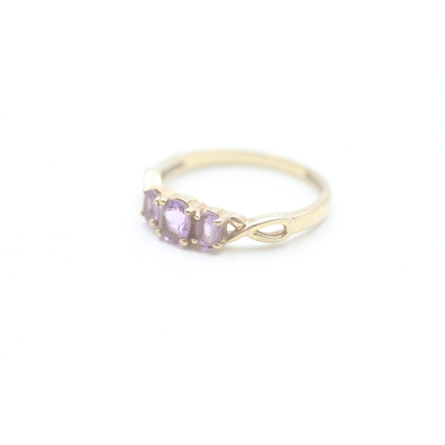 165 - 9ct gold amethyst three stone ring (1.9g) Size P