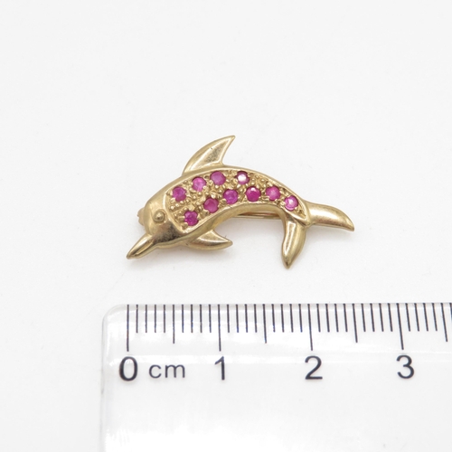 107 - 9ct gold dolphin ruby set brooch (1.9g)