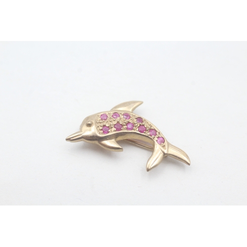 107 - 9ct gold dolphin ruby set brooch (1.9g)