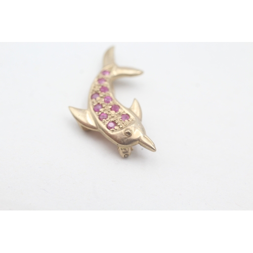 107 - 9ct gold dolphin ruby set brooch (1.9g)