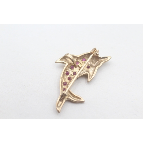 107 - 9ct gold dolphin ruby set brooch (1.9g)