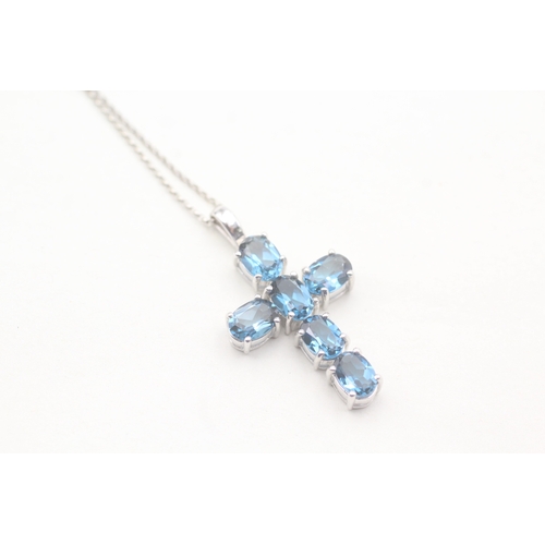 124 - 9ct gold blue topaz cross pendant on chain (5.9g)