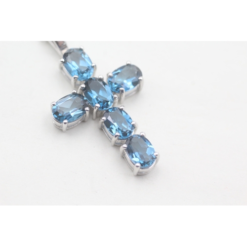 124 - 9ct gold blue topaz cross pendant on chain (5.9g)