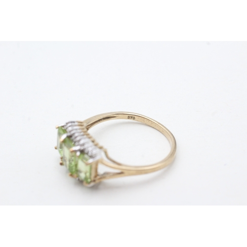 202 - 9ct gold peridot three stone ring with diamond accents (3g) Size R