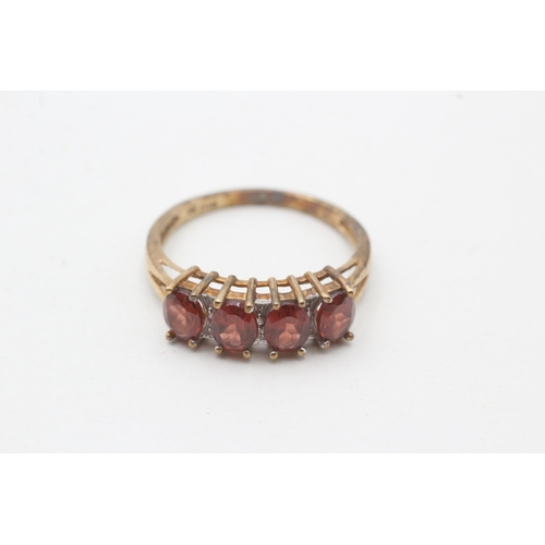 74 - 9ct gold garnet four stone ring with diamond spacers (2.3g) Size P