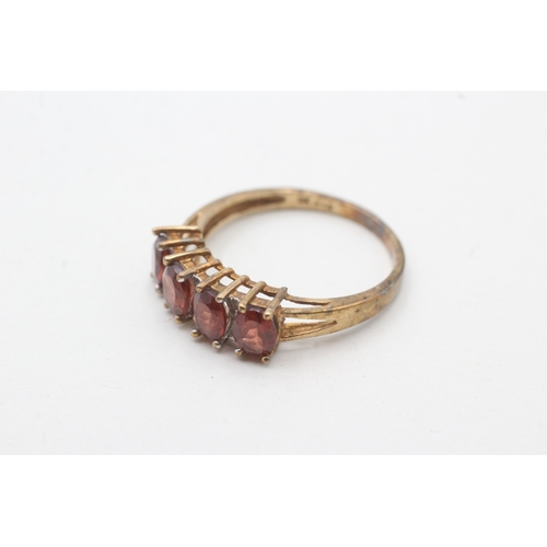 74 - 9ct gold garnet four stone ring with diamond spacers (2.3g) Size P