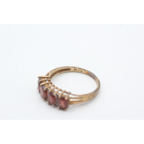 74 - 9ct gold garnet four stone ring with diamond spacers (2.3g) Size P