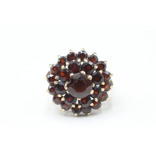 79 - 9ct gold garnet double halo cluster ring (5.4g) Size O 1/2