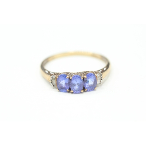 82 - 9ct gold tanzanite three stone ring with calibre cut diamond sides (2g) Size V