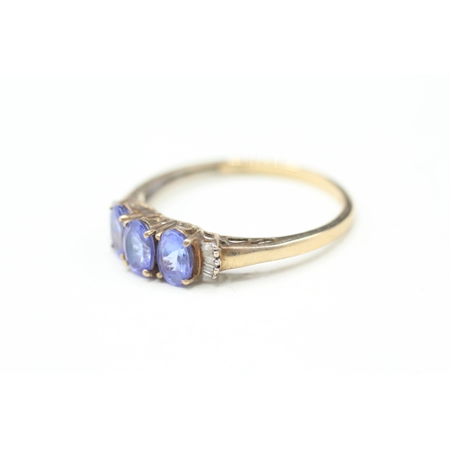 82 - 9ct gold tanzanite three stone ring with calibre cut diamond sides (2g) Size V