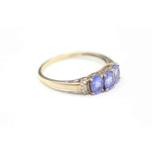 82 - 9ct gold tanzanite three stone ring with calibre cut diamond sides (2g) Size V