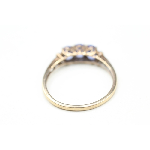 82 - 9ct gold tanzanite three stone ring with calibre cut diamond sides (2g) Size V