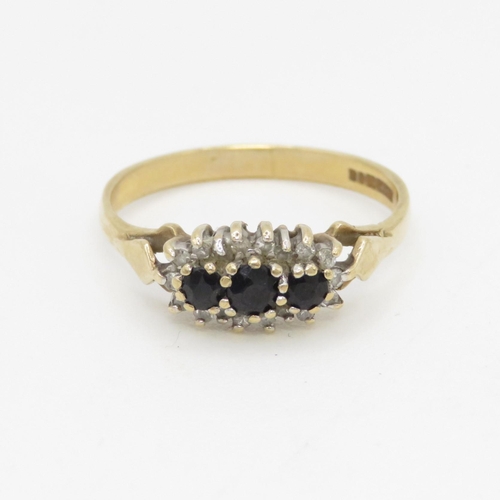 115 - 9ct gold sapphire three stone ring with diamond surround (1.5g) Size M