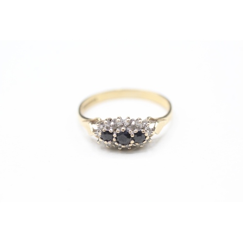 115 - 9ct gold sapphire three stone ring with diamond surround (1.5g) Size M