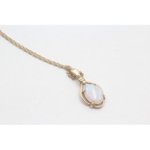 87 - 9ct gold and opal cabochon pendant on chain (2.1g)