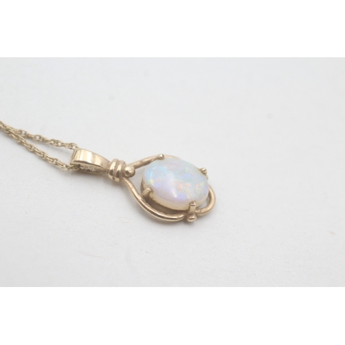 87 - 9ct gold and opal cabochon pendant on chain (2.1g)