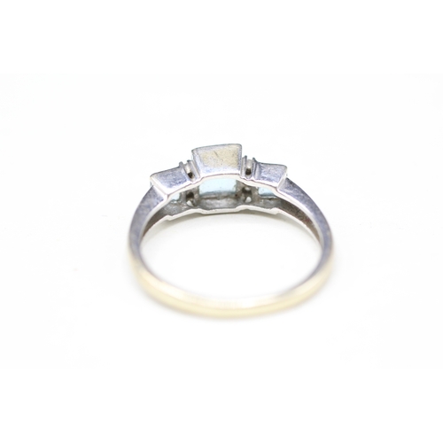 110 - 9ct white gold topaz three stone ring with diamond spacers (2.3g) Size M