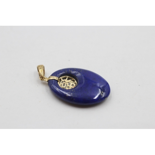 126 - 14ct gold lapis lazuli open space carved pendant (3.3g)