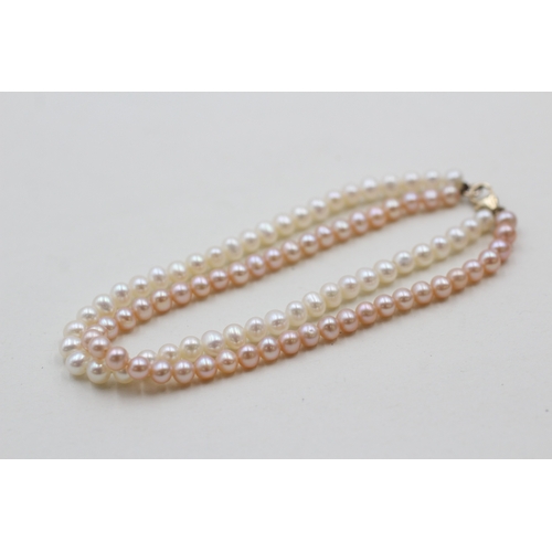 146 - 9ct gold twin strand cultured pearl bracelet (10.7g)