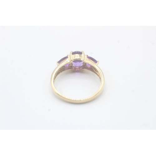 58 - 9ct gold amethyst three stone ring (2.2g) Size O