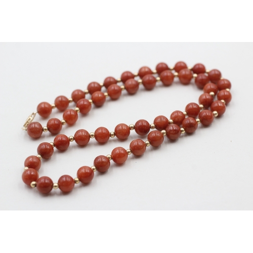 64 - 14ct gold clasped red jade beaded necklace with gold spacers (40.8g)