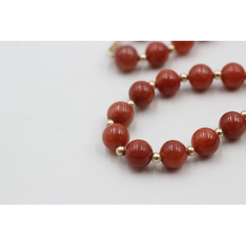 64 - 14ct gold clasped red jade beaded necklace with gold spacers (40.8g)