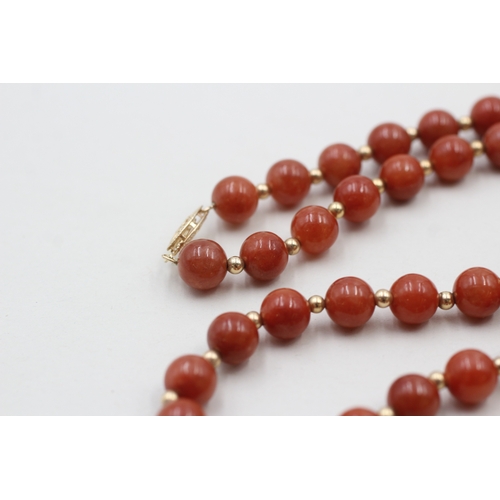 64 - 14ct gold clasped red jade beaded necklace with gold spacers (40.8g)