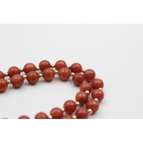 64 - 14ct gold clasped red jade beaded necklace with gold spacers (40.8g)