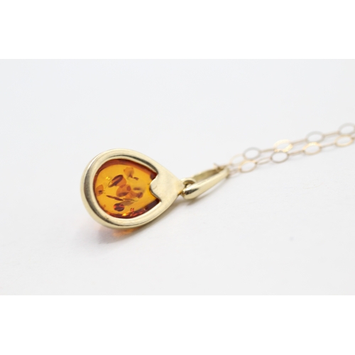 170 - 9ct gold amber pendant on chain (1.5g)