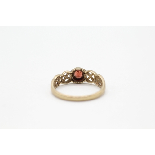 94 - 9ct gold and garnet ring with twisted design band (1.6g) Size N