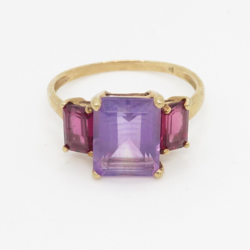 76 - 9ct gold amethyst and  garnet set trilogy cocktail ring (2.4g) Size P