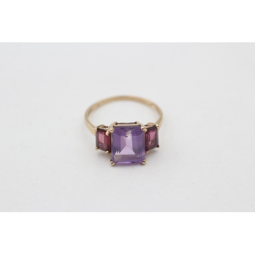 76 - 9ct gold amethyst and  garnet set trilogy cocktail ring (2.4g) Size P