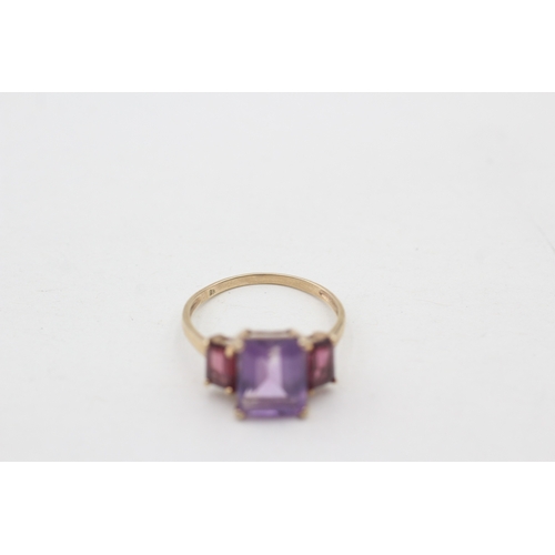 76 - 9ct gold amethyst and  garnet set trilogy cocktail ring (2.4g) Size P