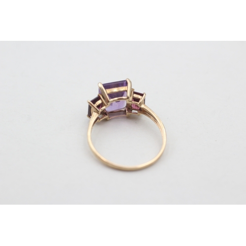 76 - 9ct gold amethyst and  garnet set trilogy cocktail ring (2.4g) Size P