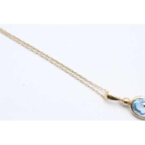 237 - 9ct gold blue topaz pendant on chain (0.9g)