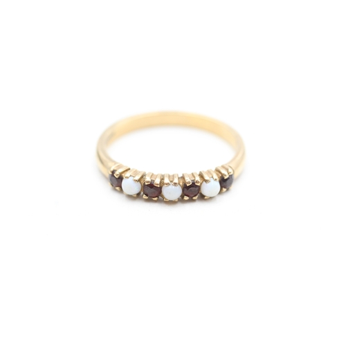 249 - 9ct gold garnet and opal set seven stone eternity ring (2.5g) Size Q