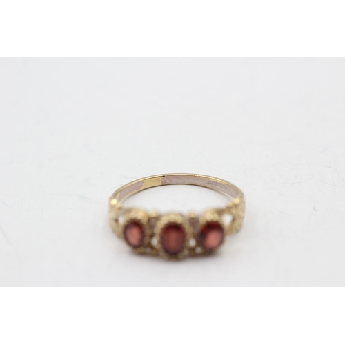 34 - 9ct gold garnet trilogy ring (2.1g) Size P