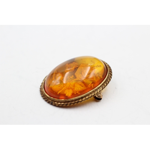 7 - 9ct gold reverse carved amber brooch (4g)