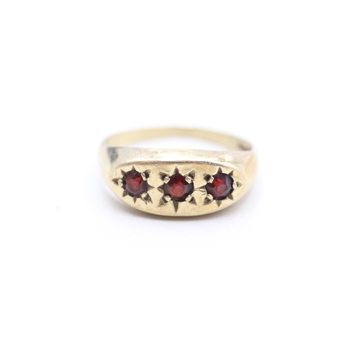 214 - 9ct gold star set garnet trilogy ring (3.4g) Size T