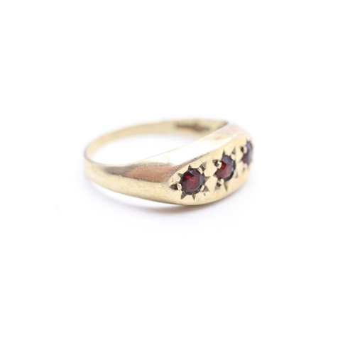 214 - 9ct gold star set garnet trilogy ring (3.4g) Size T