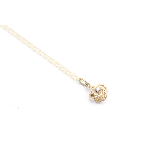 239 - 9ct gold diamond knot pendant on chain (1.7g)