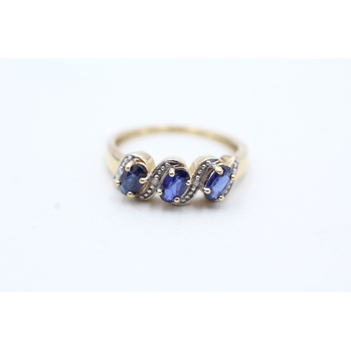 94 - 9ct gold diamond and blue gemstone twist row ring (2.1g) Size N