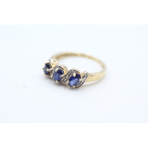 94 - 9ct gold diamond and blue gemstone twist row ring (2.1g) Size N