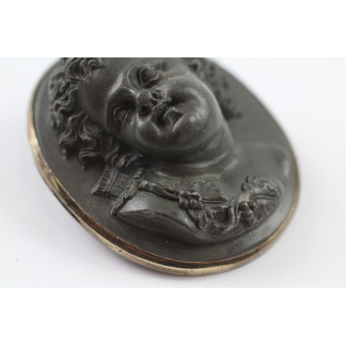 131 - Low carat gold rimmed large lavastone cameo cherub brooch (26.5g)