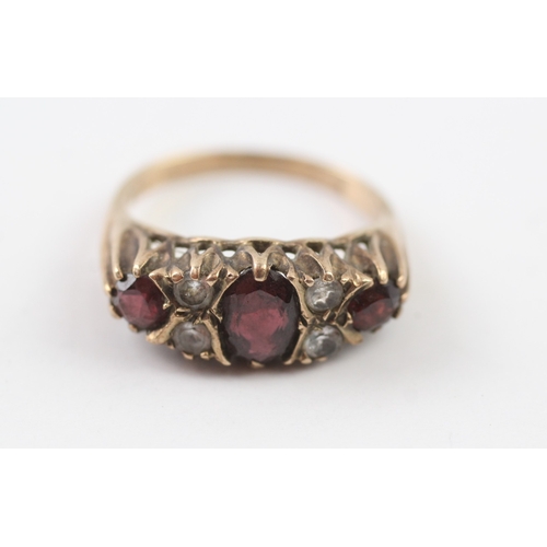 215 - 9ct gold garnet and white gemstone gypsy set ring (3.8g) Size O 1/2