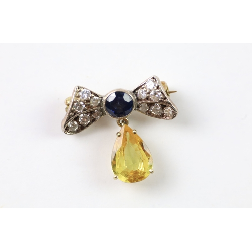 383 - A gold and silver bow brooch set with diamond and yellow and blue sapphires (2.6g)