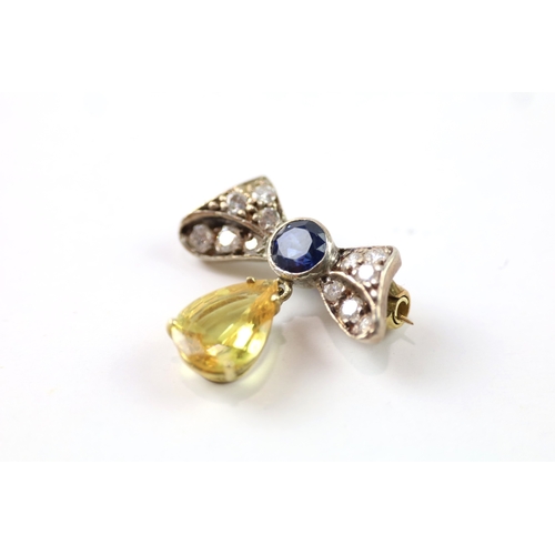 383 - A gold and silver bow brooch set with diamond and yellow and blue sapphires (2.6g)