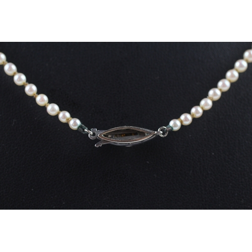 408 - Gold and diamond clasped imitation pearl necklace (11.7g)