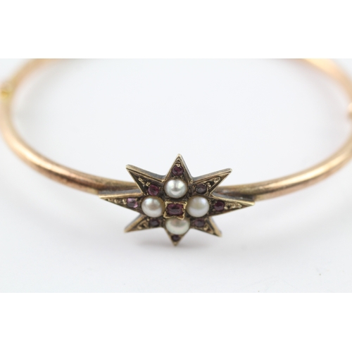 426 - 14ct gold ruby and seed pearl set starburst bangle (7.9g)